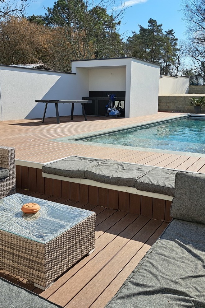 Terrazza in legno composito Silvadec intorno a una piscina con salotto da giardino, arredamento esterno di alta gamma