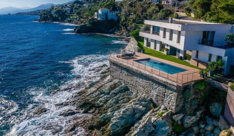 Villa contemporaine en Corse avec terrasse en bois composite Nuances Ipé de Silvadec et piscine à débordement sur structure aluminium Réversil, offrant une vue panoramique sur la Méditerranée